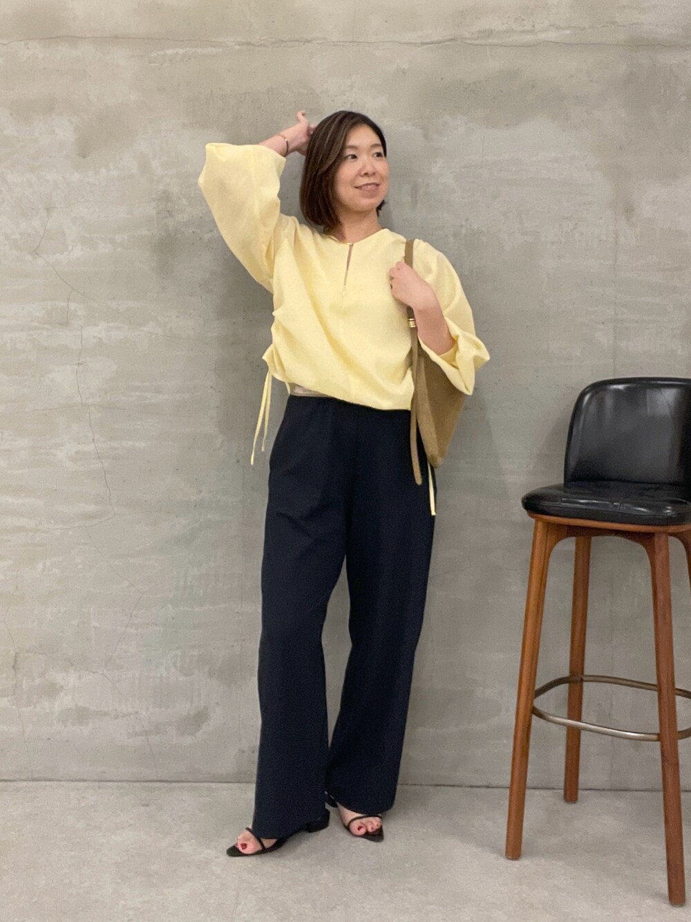 ブラック系のその他パンツ、ベージュ系のショルダーバッグ、イエロー系のシャツ/ブラウスを着用したレディースの夏コーディネートの4枚目の写真