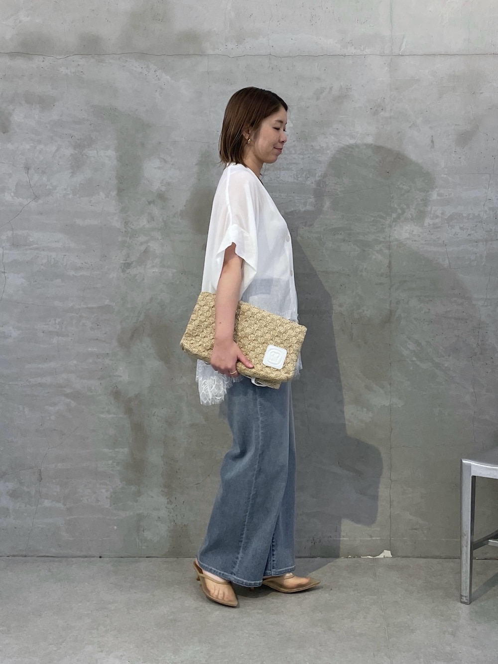 ホワイト系のシャツ/ブラウス、ブルー系のデニムパンツ、ホワイト系のトートバッグを着用したレディースの春コーディネートの2枚目の写真