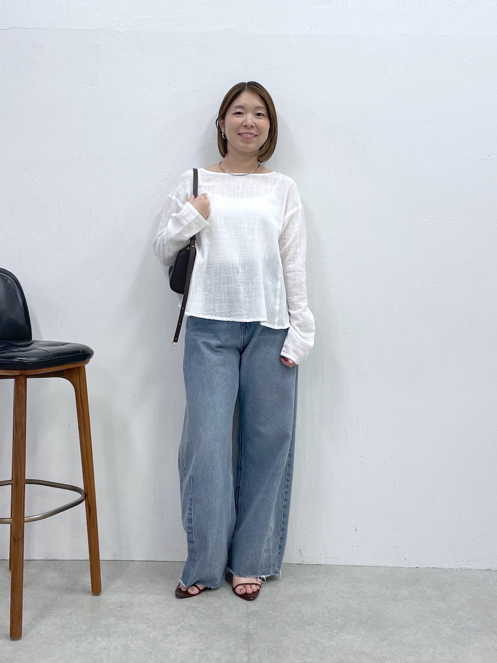 ホワイト系のシャツ/ブラウス、ブルー系のデニムパンツ、ブラック系のショルダーバッグを着用したレディースの夏コーディネートの4枚目の写真