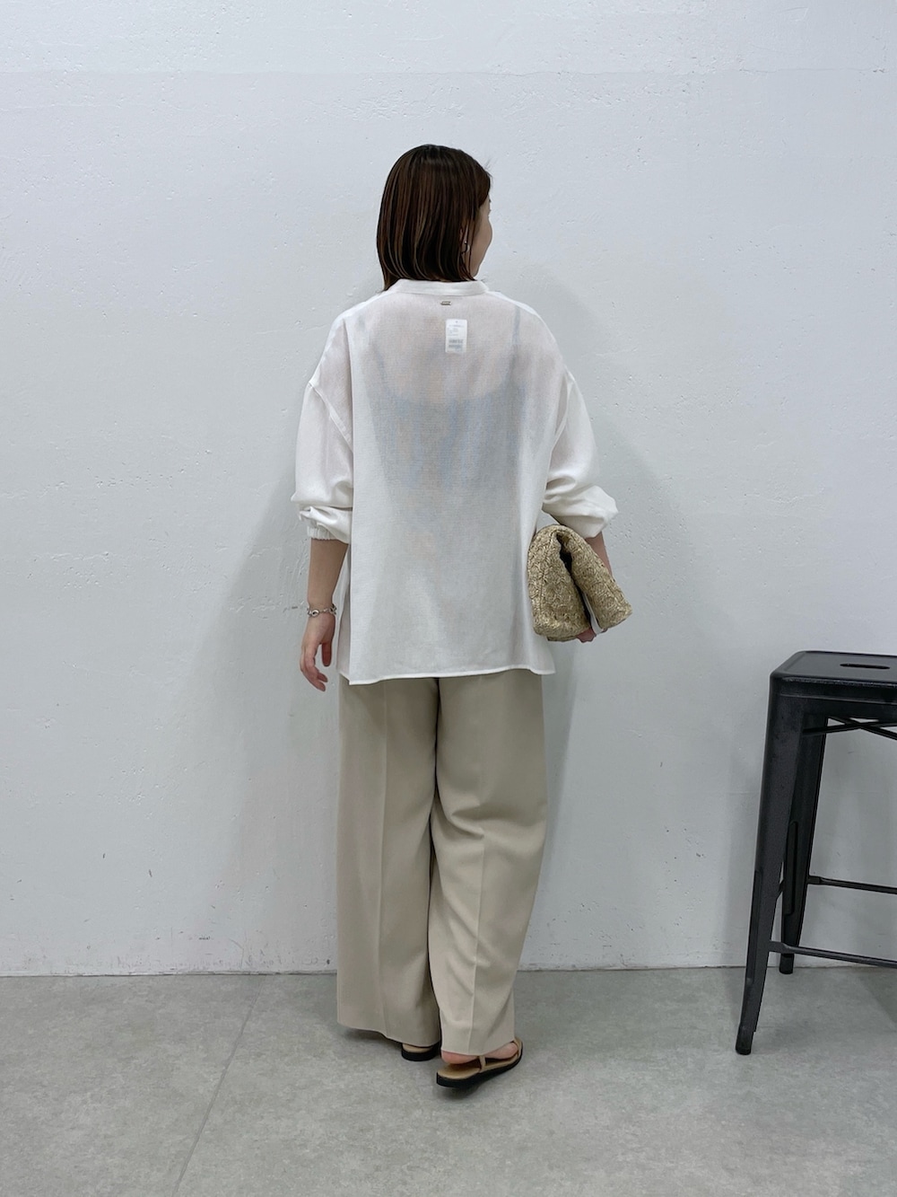 ホワイト系のシャツ/ブラウス、ベージュ系のスラックス、ホワイト系のトートバッグを着用したレディースの春コーディネートの3枚目の写真