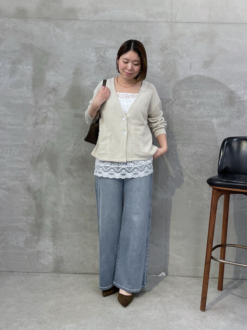 ベージュ系のカーディガン/ボレロ、ホワイト系のキャミソール、ブルー系のデニムパンツを着用したレディースの冬コーディネートの5枚目の写真