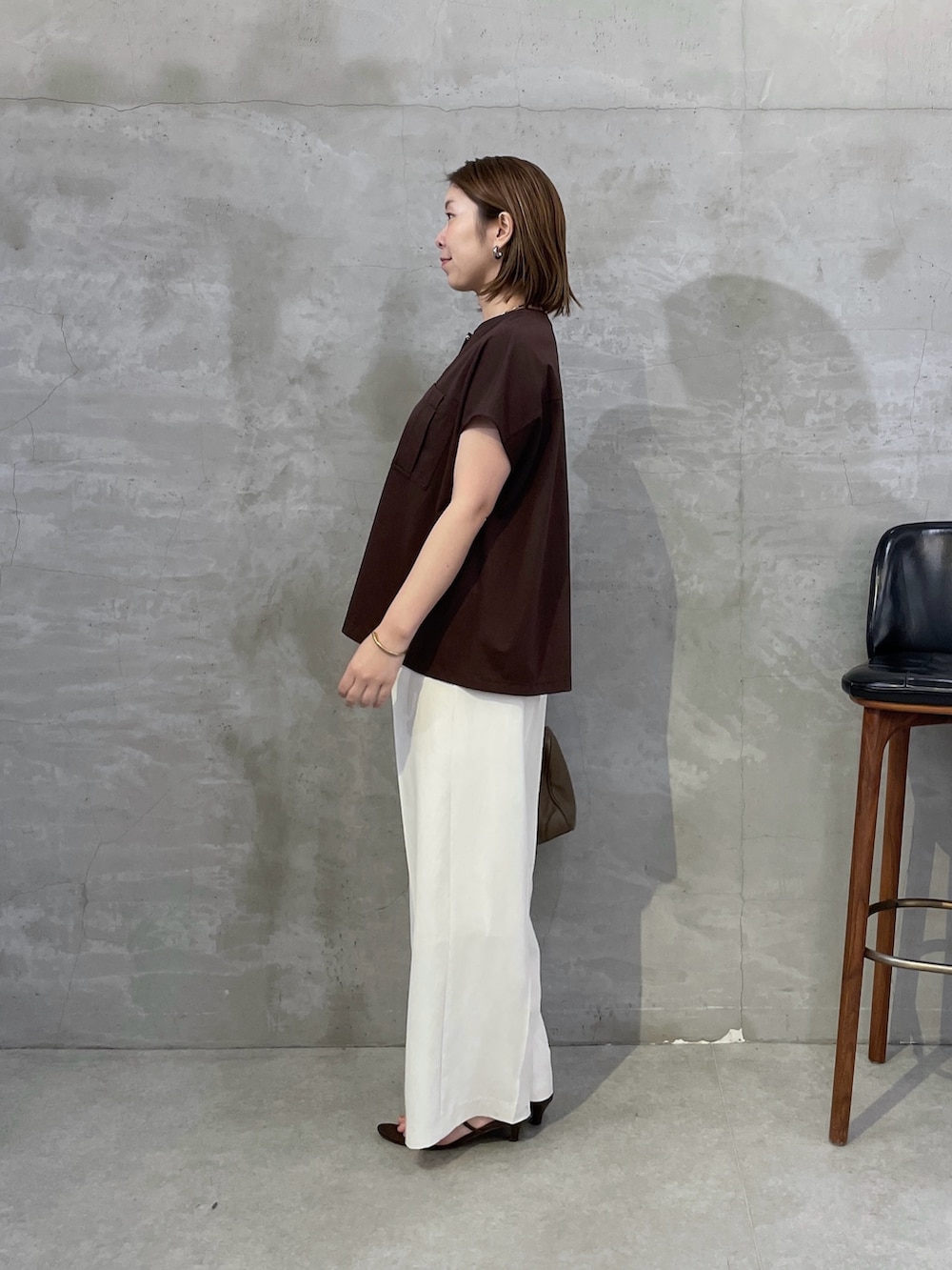 ブラウン系のTシャツ/カットソー、ホワイト系のスラックス、ブラウン系のボストンバッグを着用したレディースの夏コーディネートの4枚目の写真