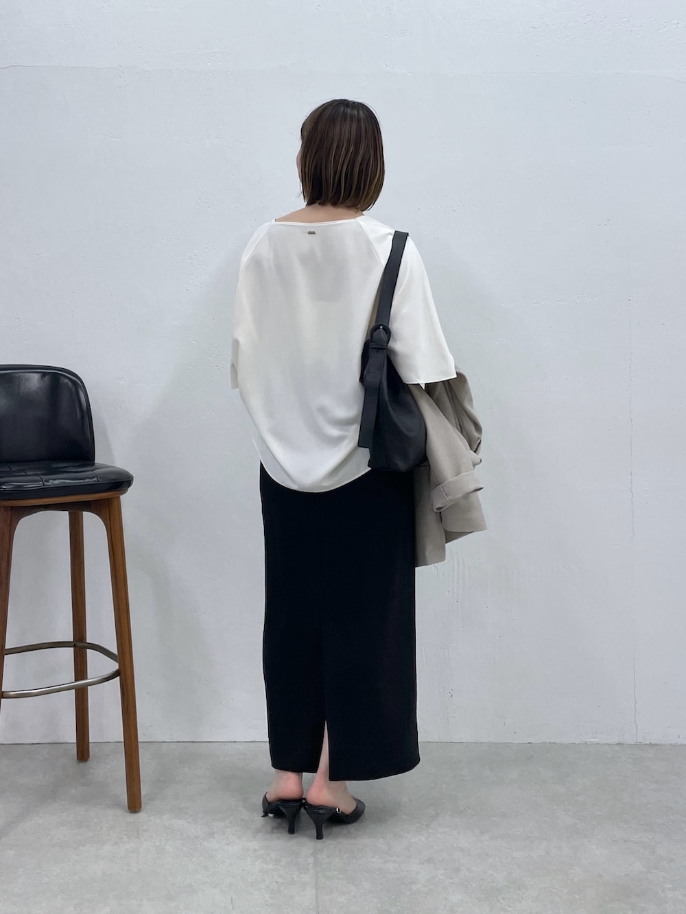 ブラック系のスカート、ベージュ系のテーラードジャケット、ホワイト系のシャツ/ブラウスを着用したレディースの春コーディネートの3枚目の写真