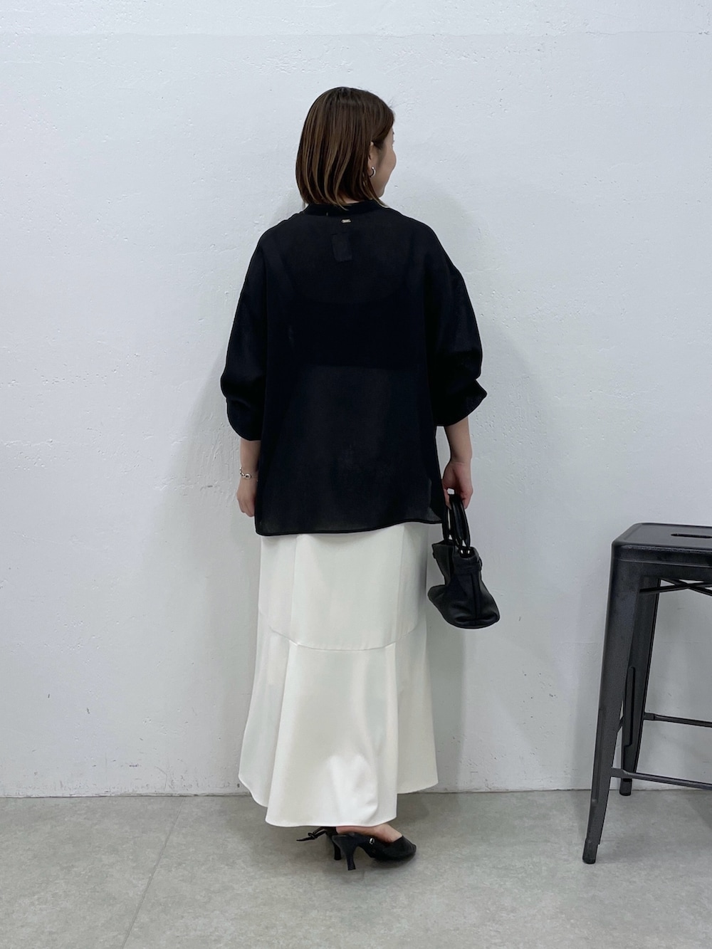 ホワイト系のスカート、ブラック系のトートバッグ、ブラック系のシャツ/ブラウスを着用したレディースの春コーディネートの3枚目の写真