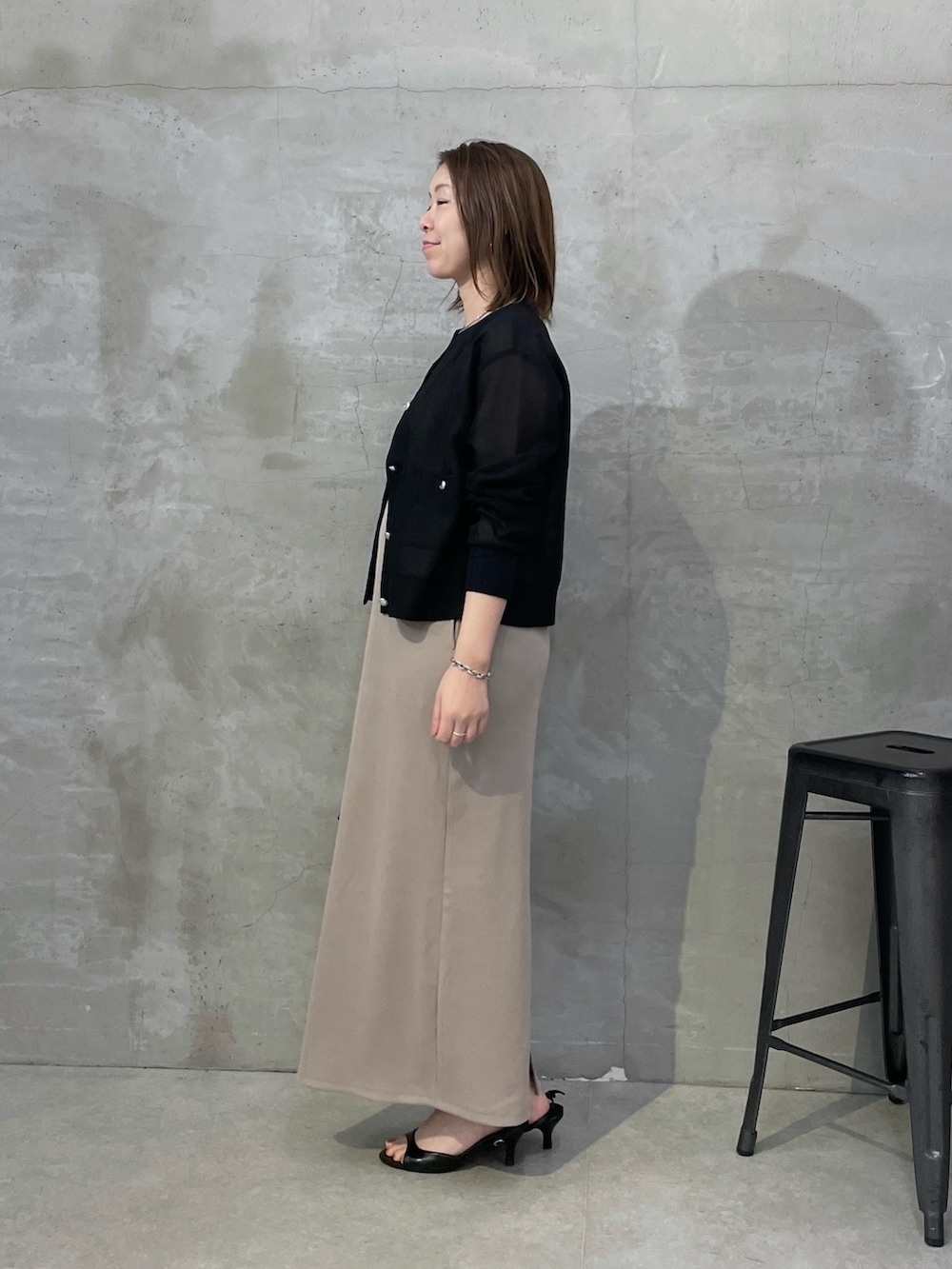 ブラック系のカーディガン/ボレロ、ベージュ系のワンピース、ブラック系のボストンバッグを着用したレディースの春コーディネートの2枚目の写真