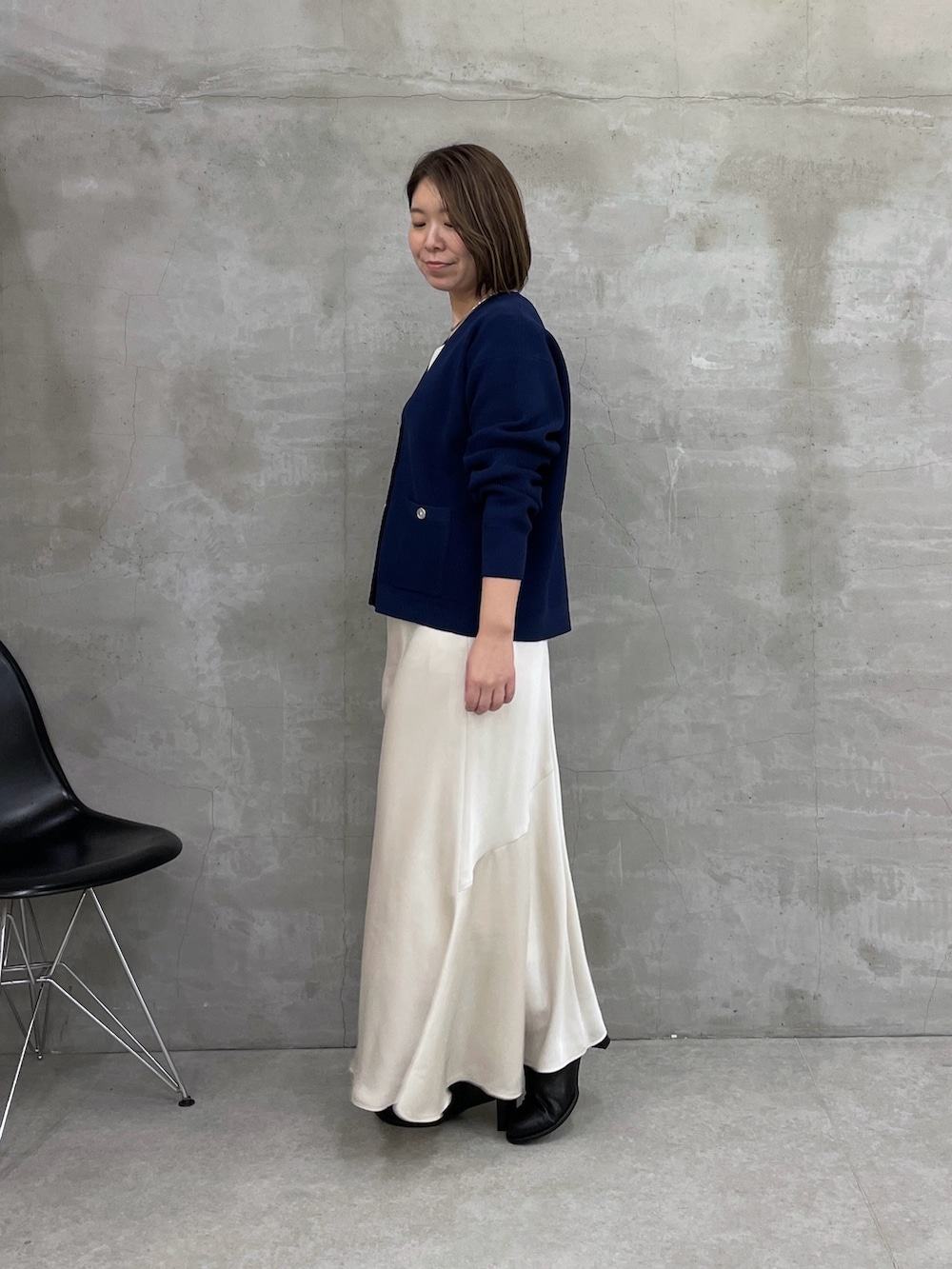 ホワイト系のスカート、ブルー系のカーディガン/ボレロ、ブラック系のボストンバッグを着用したレディースの冬コーディネートの2枚目の写真