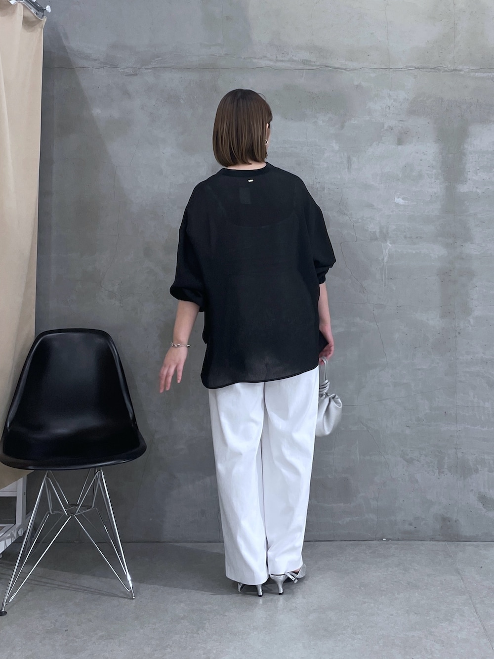 ブラック系のシャツ/ブラウス、ホワイト系のスラックスを着用したレディースの春コーディネートの3枚目の写真