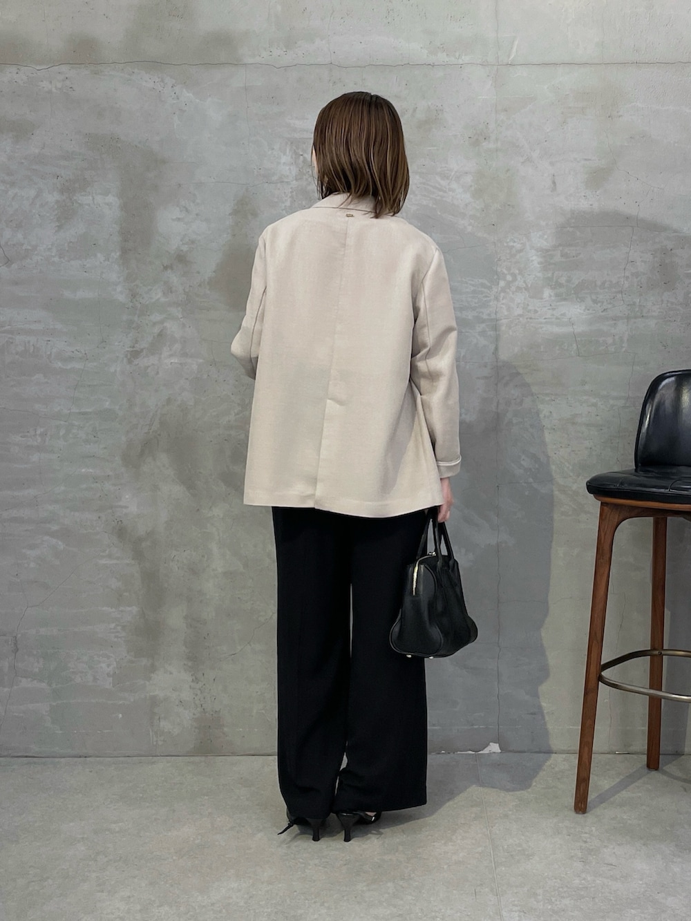 ベージュ系のテーラードジャケット、ホワイト系のシャツ/ブラウス、ブラック系のスラックスを着用したレディースの春コーディネートの3枚目の写真