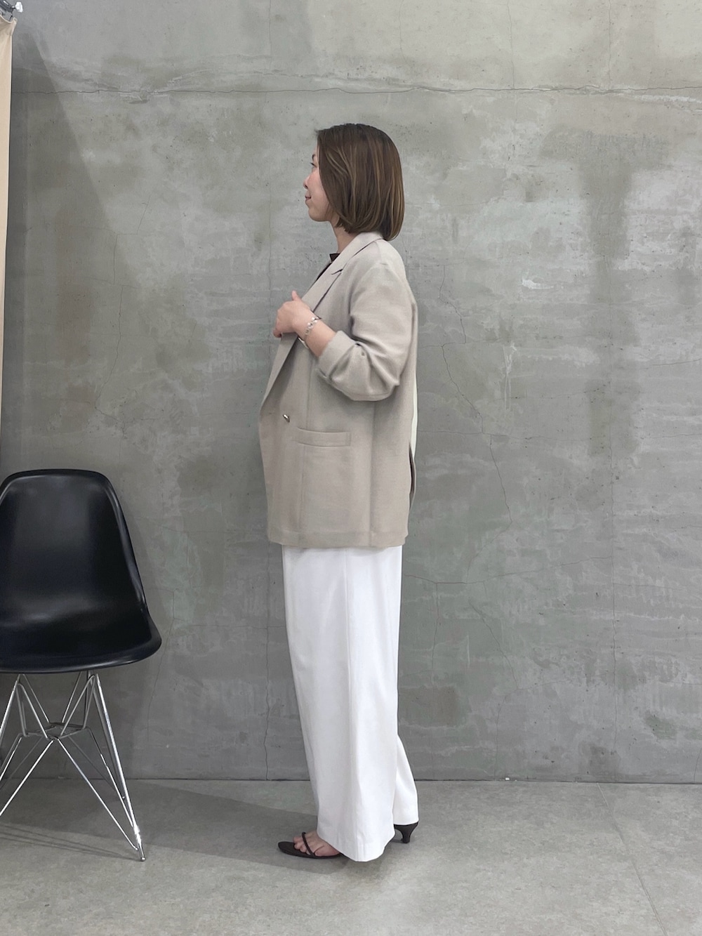 ベージュ系のテーラードジャケット、ブラウン系のTシャツ/カットソー、ホワイト系のスラックスを着用したレディースの春コーディネートの2枚目の写真