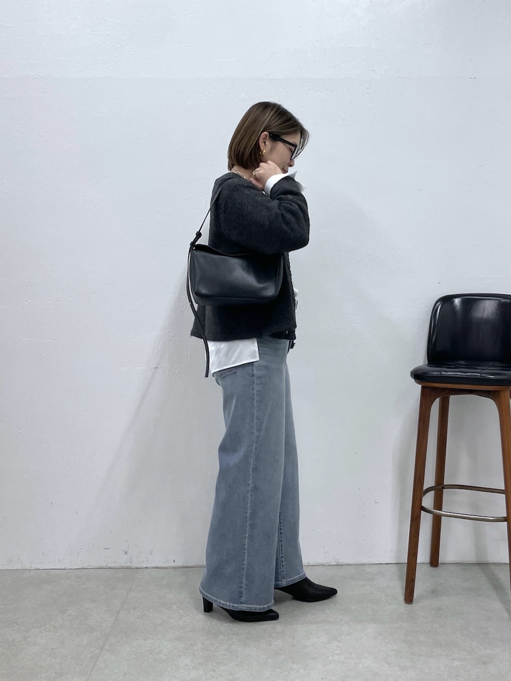 グレー系のカーディガン/ボレロ、ホワイト系のシャツ/ブラウス、ブルー系のデニムパンツを着用したレディースの秋コーディネートの2枚目の写真