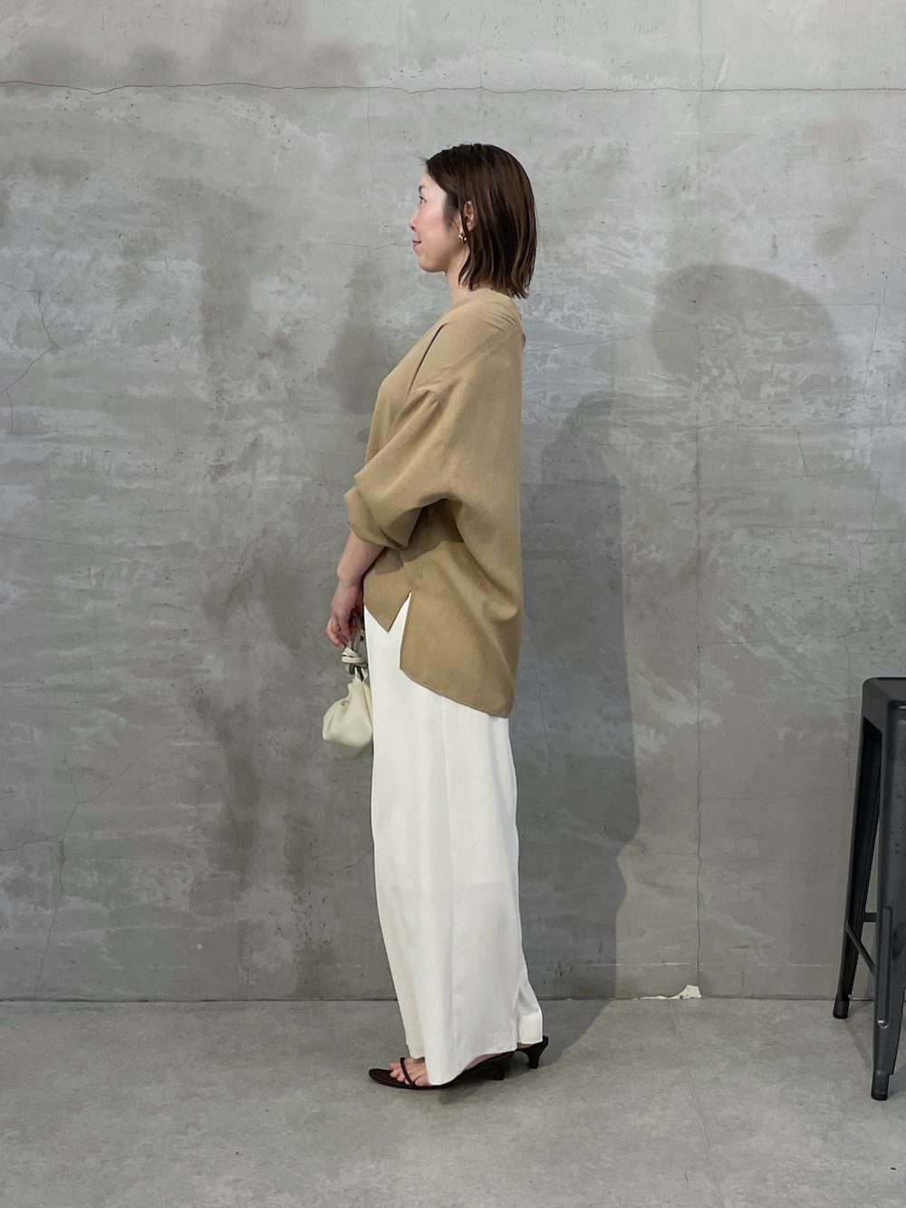 ベージュ系のシャツ/ブラウス、ホワイト系のスラックス、ホワイト系のショルダーバッグを着用したレディースの春コーディネートの4枚目の写真