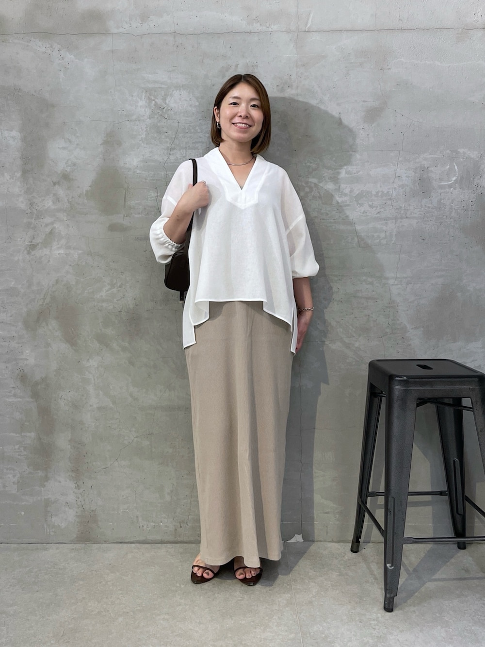 ホワイト系のシャツ/ブラウス、ベージュ系のワンピース、ブラウン系のショルダーバッグを着用したレディースの夏コーディネートの4枚目の写真