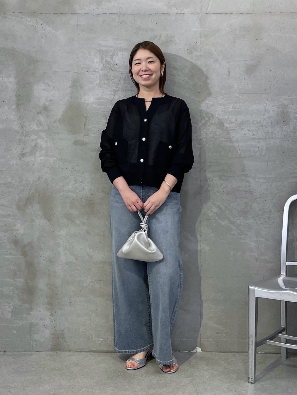 ブルー系のデニムパンツ、ブラック系のカーディガン/ボレロ、シルバー系のネックレスを着用したレディースの春コーディネートの5枚目の写真