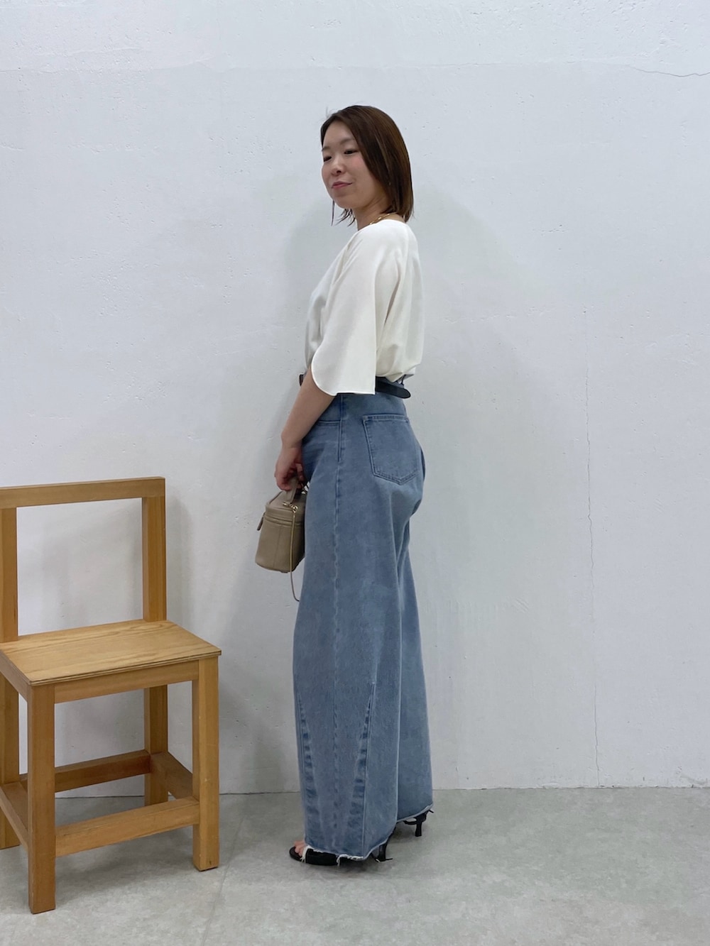 ホワイト系のシャツ/ブラウス、ブルー系のデニムパンツ、ベージュ系のショルダーバッグを着用したレディースの春コーディネートの4枚目の写真