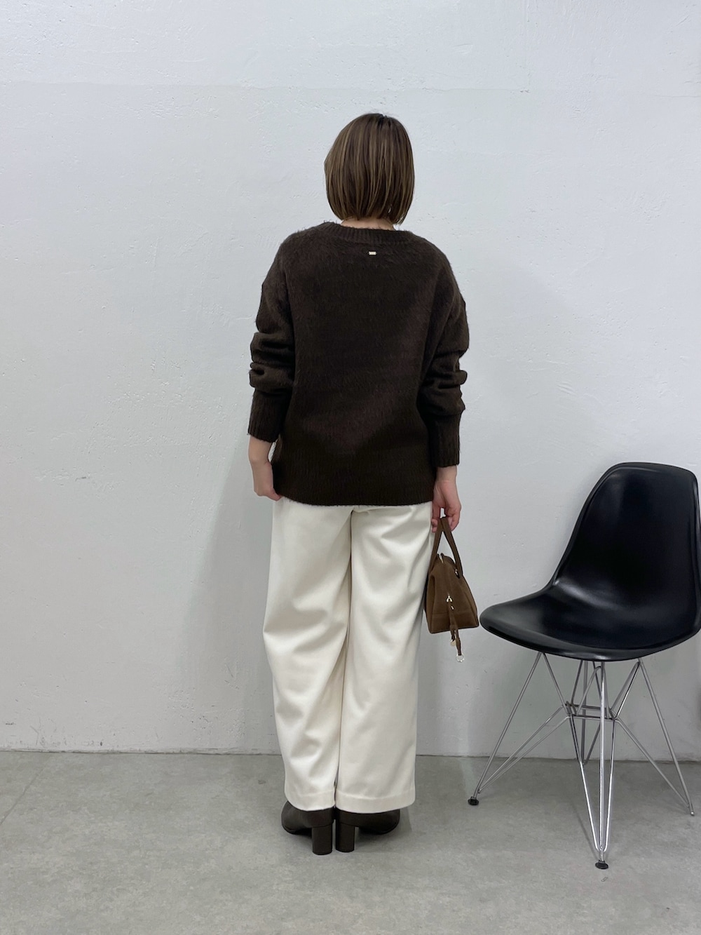 ブラウン系のニット/セーター、ホワイト系のその他パンツ、ブラウン系のボストンバッグを着用したレディースの冬コーディネートの3枚目の写真