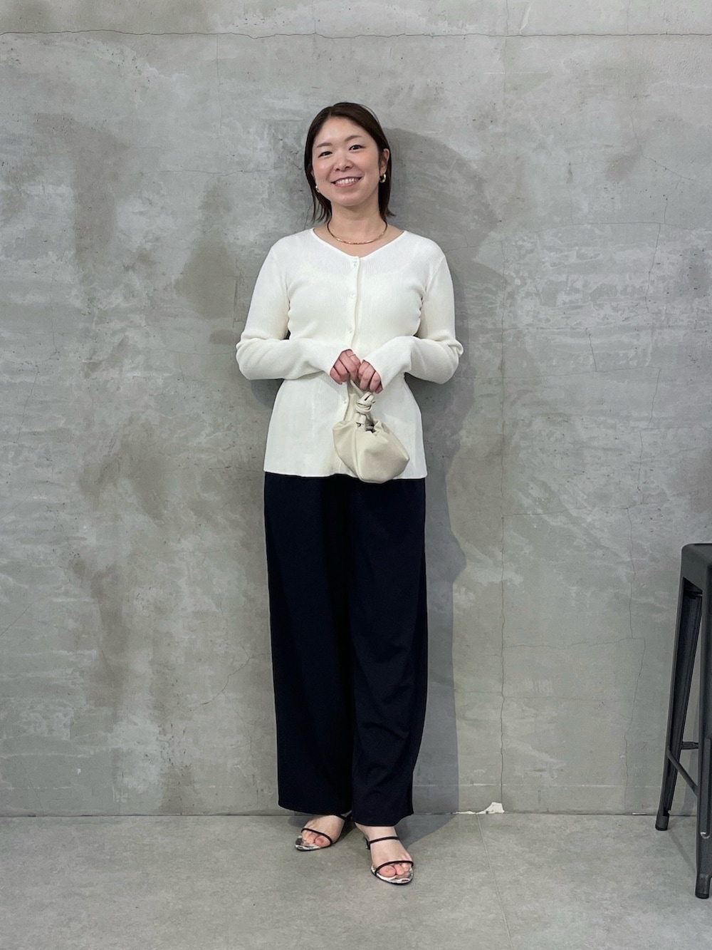 ブルー系のスラックス、ホワイト系のカーディガン/ボレロ、ゴールド系のネックレスを着用したレディースの春コーディネートの4枚目の写真