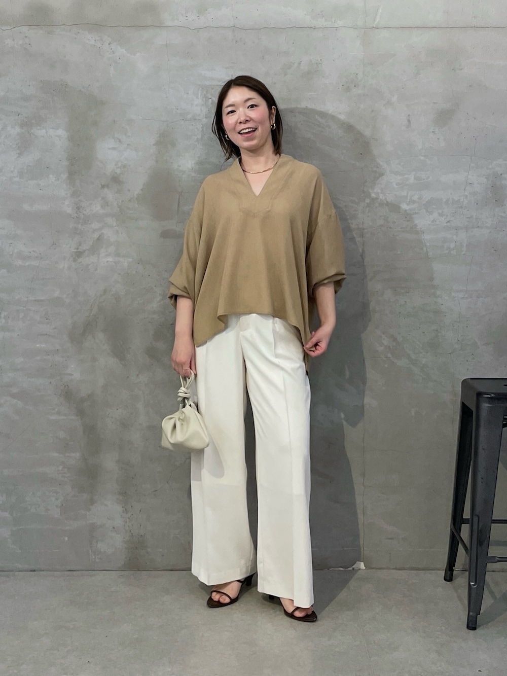 ベージュ系のシャツ/ブラウス、ホワイト系のスラックス、ホワイト系のショルダーバッグを着用したレディースの春コーディネートの5枚目の写真