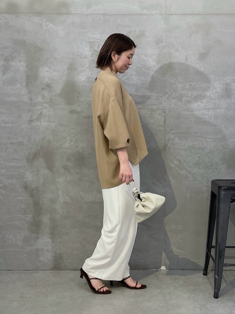 ベージュ系のシャツ/ブラウス、ホワイト系のスラックス、ホワイト系のショルダーバッグを着用したレディースの春コーディネートの2枚目の写真