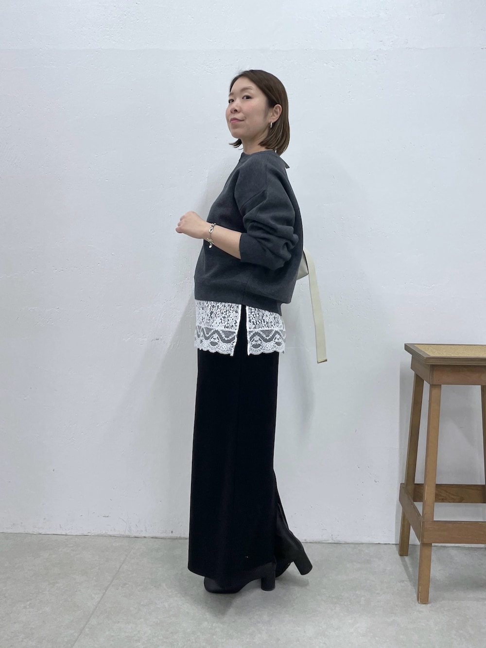 グレー系のニット/セーター、ホワイト系のキャミソール、ブラック系のスカートを着用したレディースの冬コーディネートの4枚目の写真