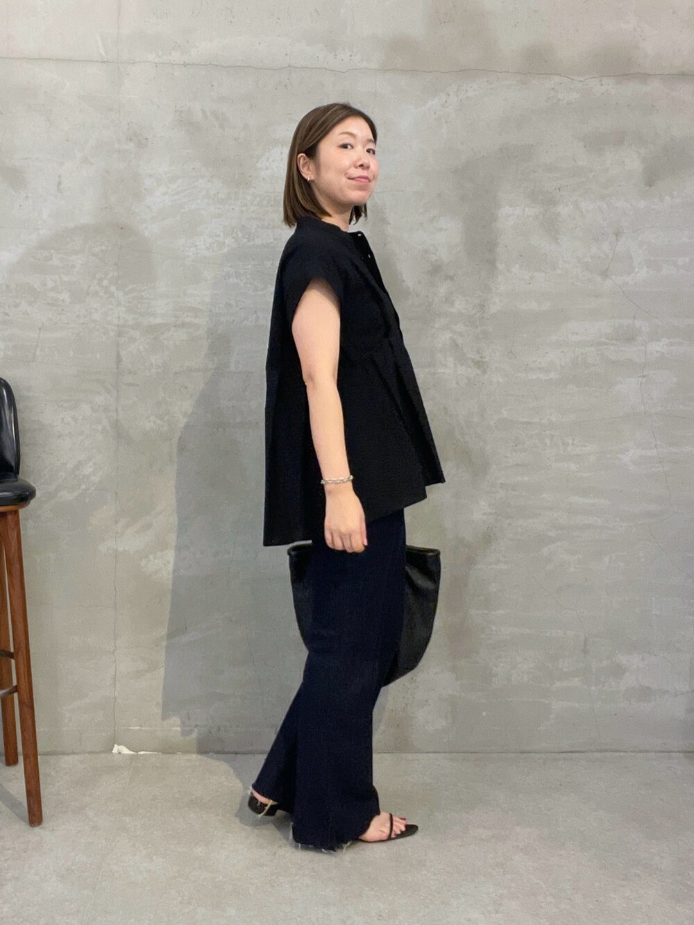 ブラック系のシャツ/ブラウス、ブルー系のデニムパンツ、ブラック系のトートバッグを着用したレディースの夏コーディネートの4枚目の写真