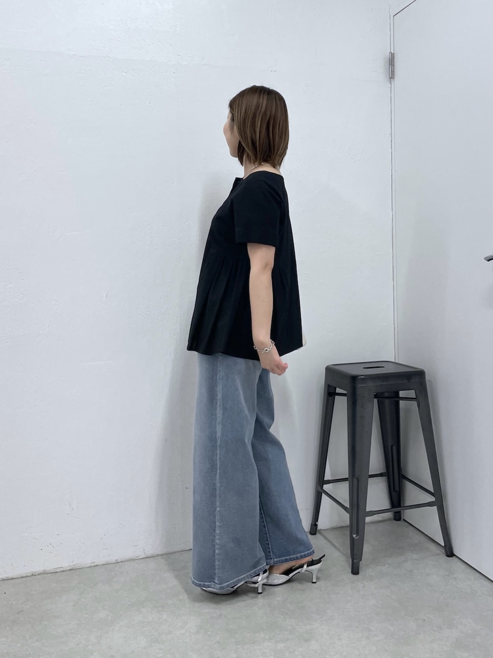ブラック系のシャツ/ブラウス、ブルー系のデニムパンツ、ホワイト系のショルダーバッグを着用したレディースの春コーディネートの5枚目の写真