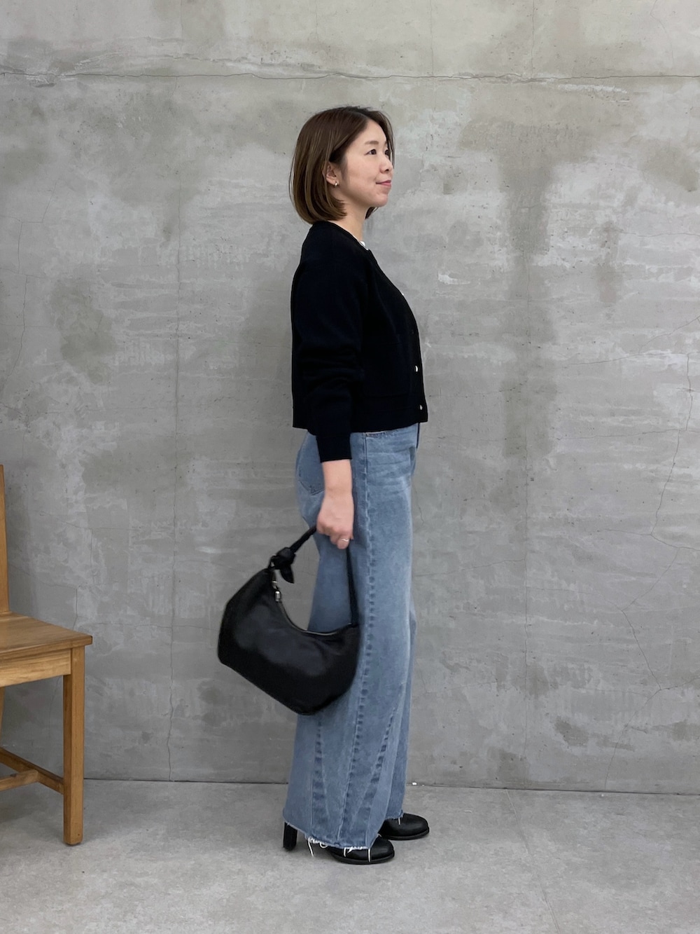 ブラック系のカーディガン/ボレロ、ブルー系のデニムパンツ、ホワイト系のTシャツ/カットソーを着用したレディースの冬コーディネートの2枚目の写真