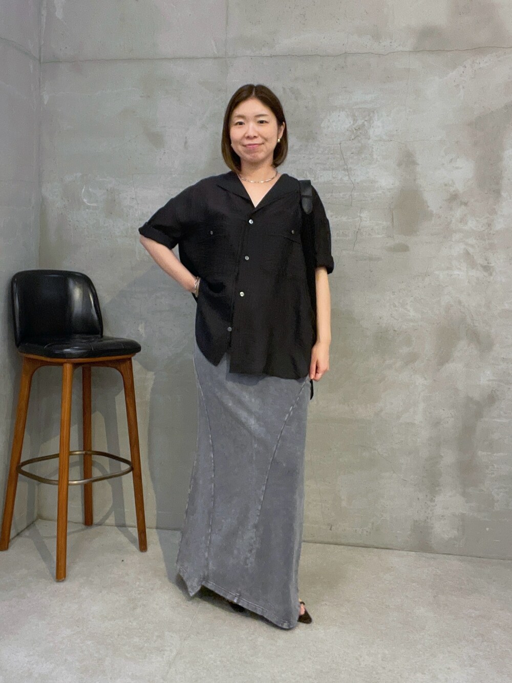 ブラック系のシャツ/ブラウス、グレー系のスカート、ブラック系のショルダーバッグを着用したレディースの夏コーディネートの4枚目の写真