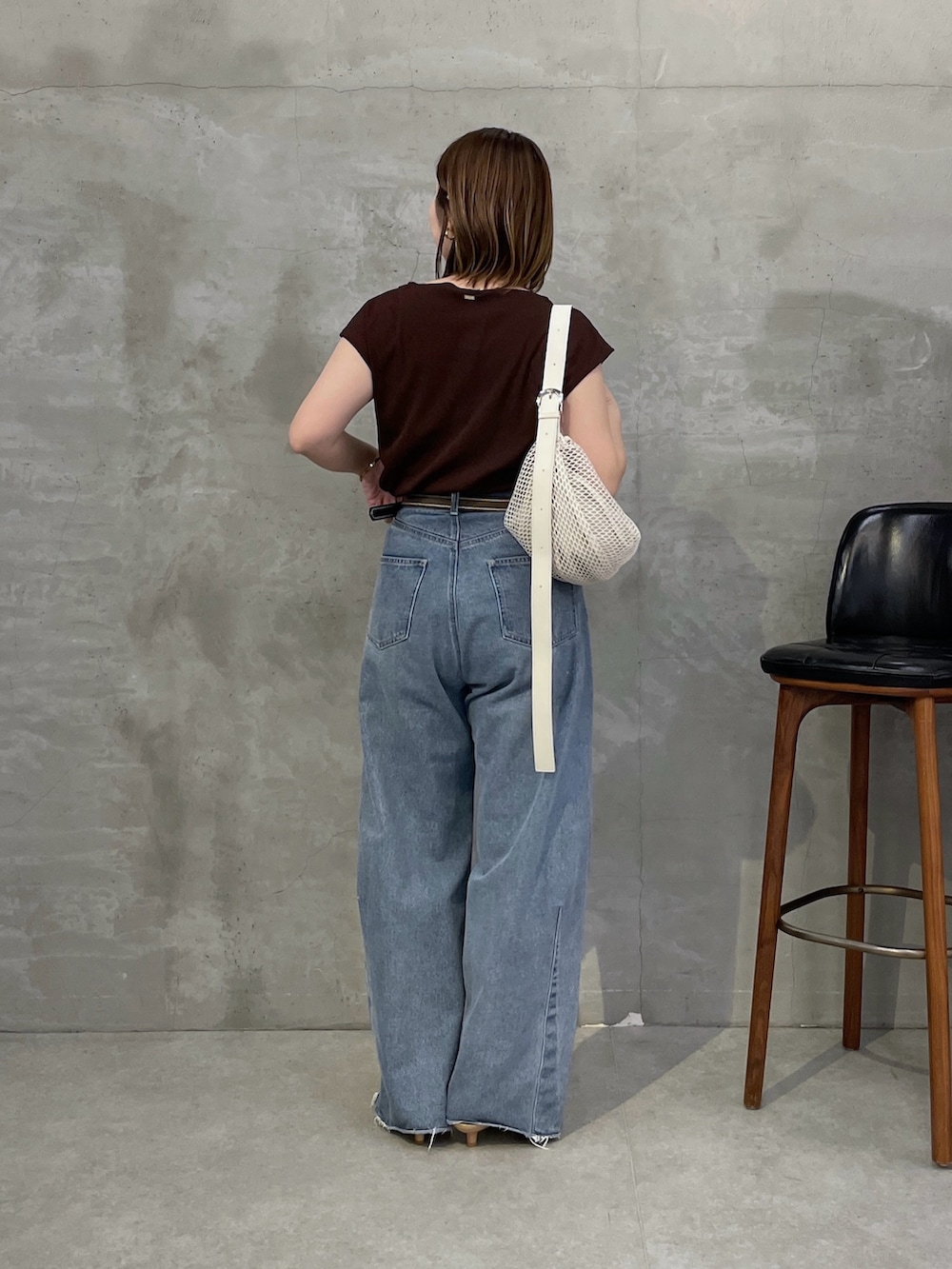 ブラウン系のTシャツ/カットソー、ブルー系のデニムパンツ、ホワイト系のショルダーバッグを着用したレディースの春コーディネートの3枚目の写真