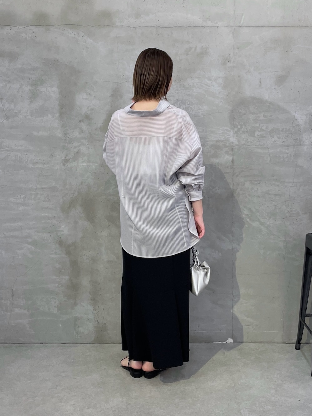 ブラック系のスカート、グレー系のシャツ/ブラウスを着用したレディースの春コーディネートの3枚目の写真