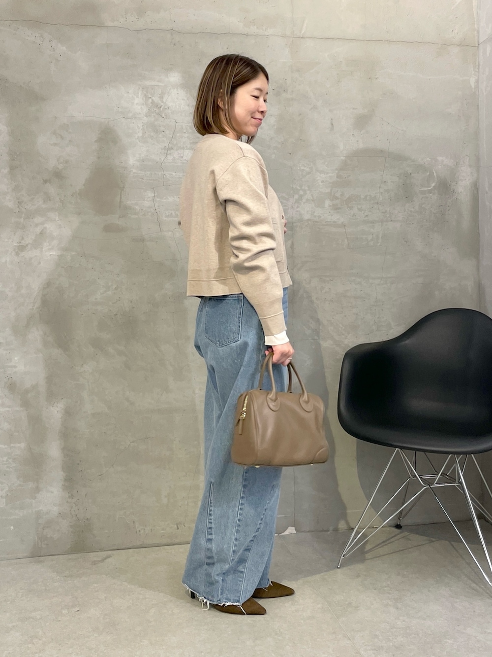 ブルー系のデニムパンツ、ベージュ系のカーディガン/ボレロ、ホワイト系のTシャツ/カットソーを着用したレディースの秋コーディネートの2枚目の写真