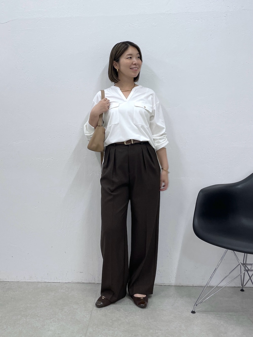 ホワイト系のTシャツ/カットソー、ブラウン系のスラックス、ベージュ系のショルダーバッグを着用したレディースの夏コーディネートの5枚目の写真
