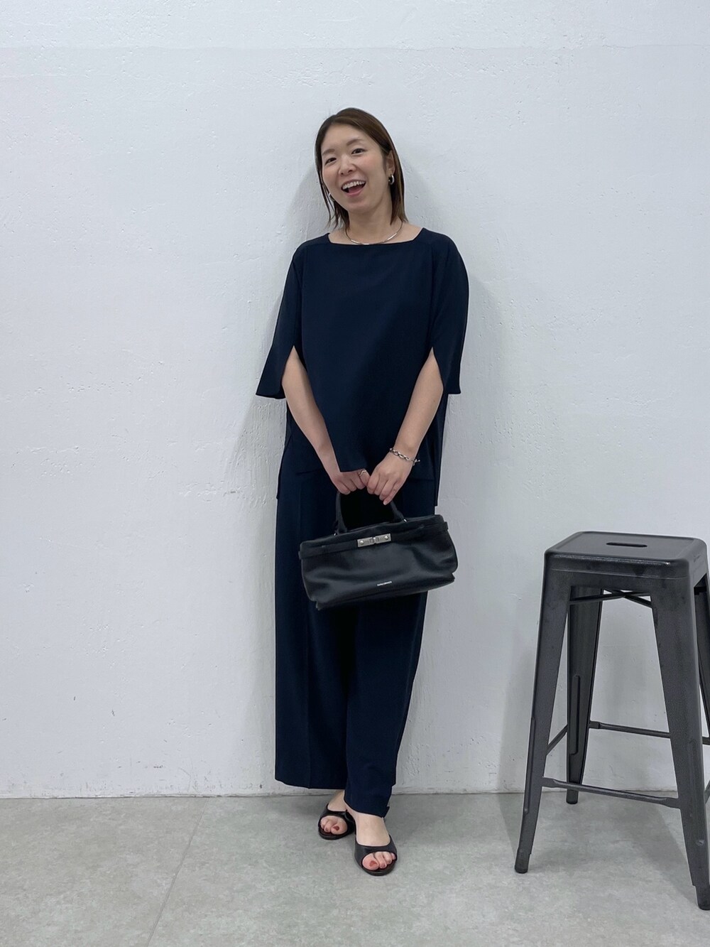 ブルー系のスラックス、ブルー系のシャツ/ブラウス、ブラック系のトートバッグを着用したレディースの春コーディネートの4枚目の写真