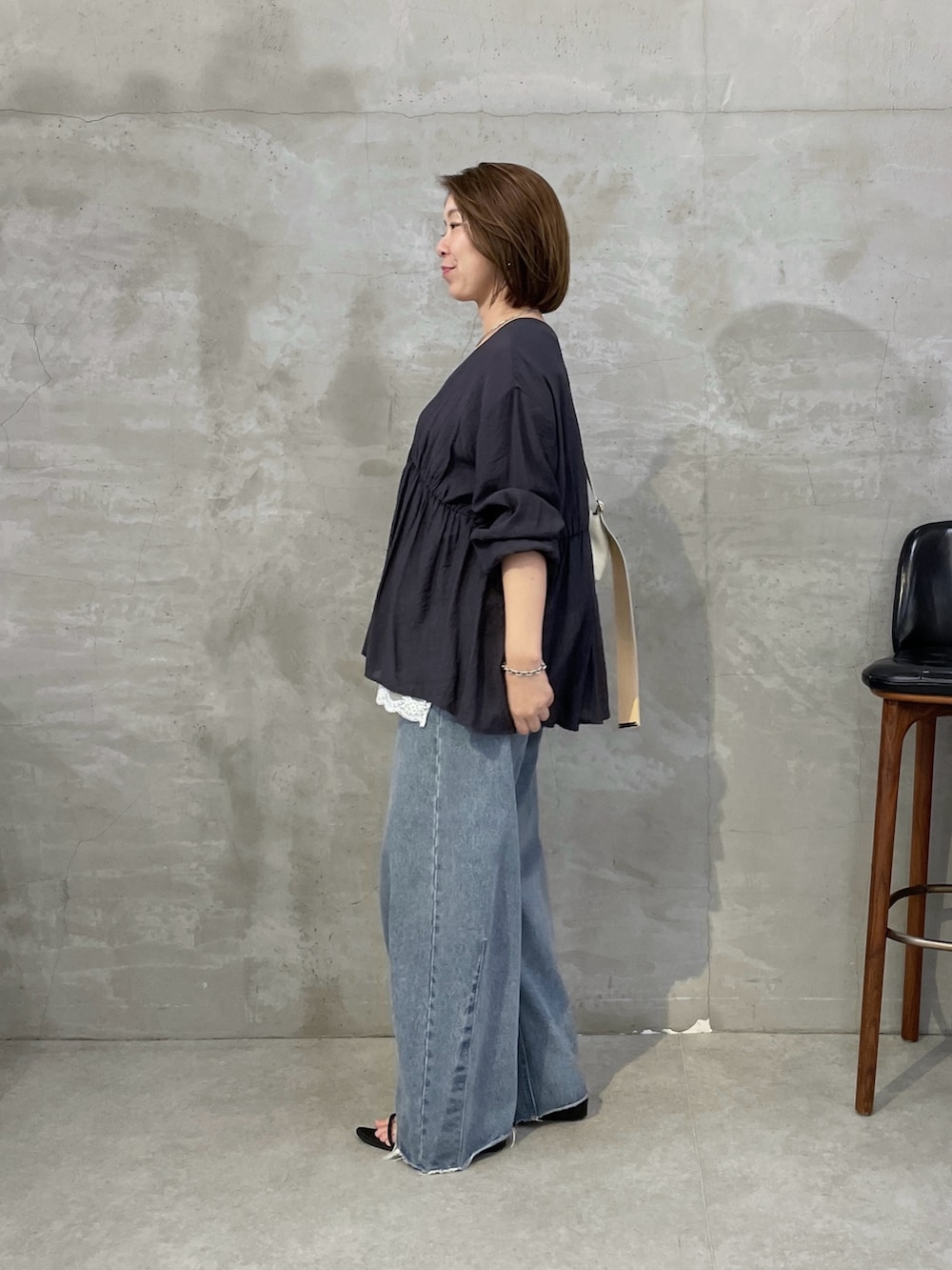 グレー系のシャツ/ブラウス、ホワイト系のキャミソール、ブルー系のデニムパンツを着用したレディースの夏コーディネートの2枚目の写真
