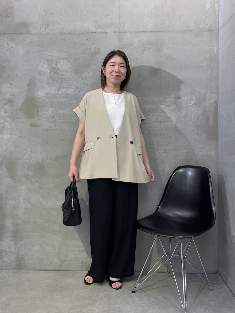 ベージュ系のテーラードジャケット、ホワイト系のTシャツ/カットソー、ブラック系のスラックスを着用したレディースの春コーディネートの4枚目の写真