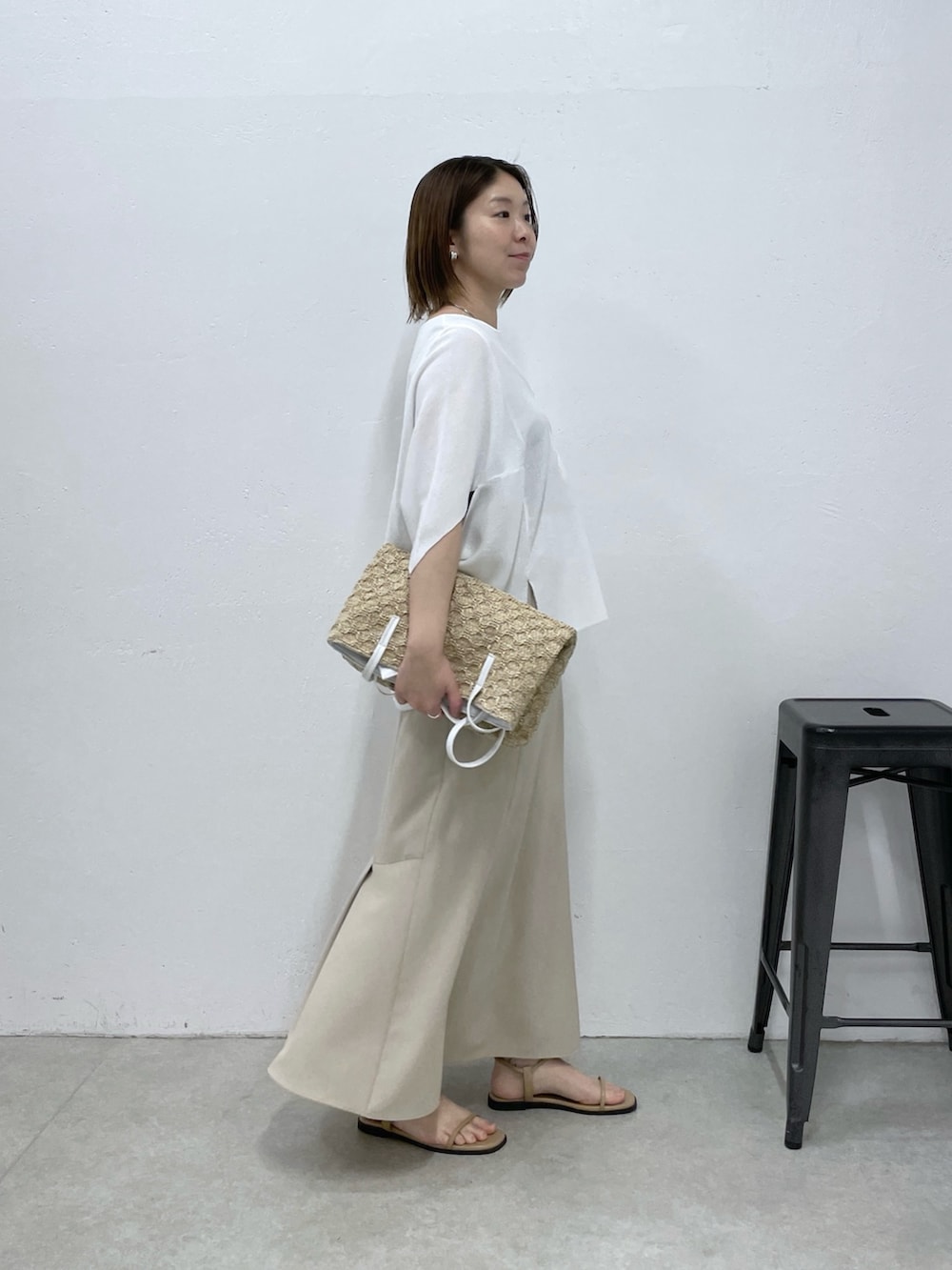 ホワイト系のTシャツ/カットソー、ベージュ系のスカート、ホワイト系のトートバッグを着用したレディースの春コーディネートの2枚目の写真