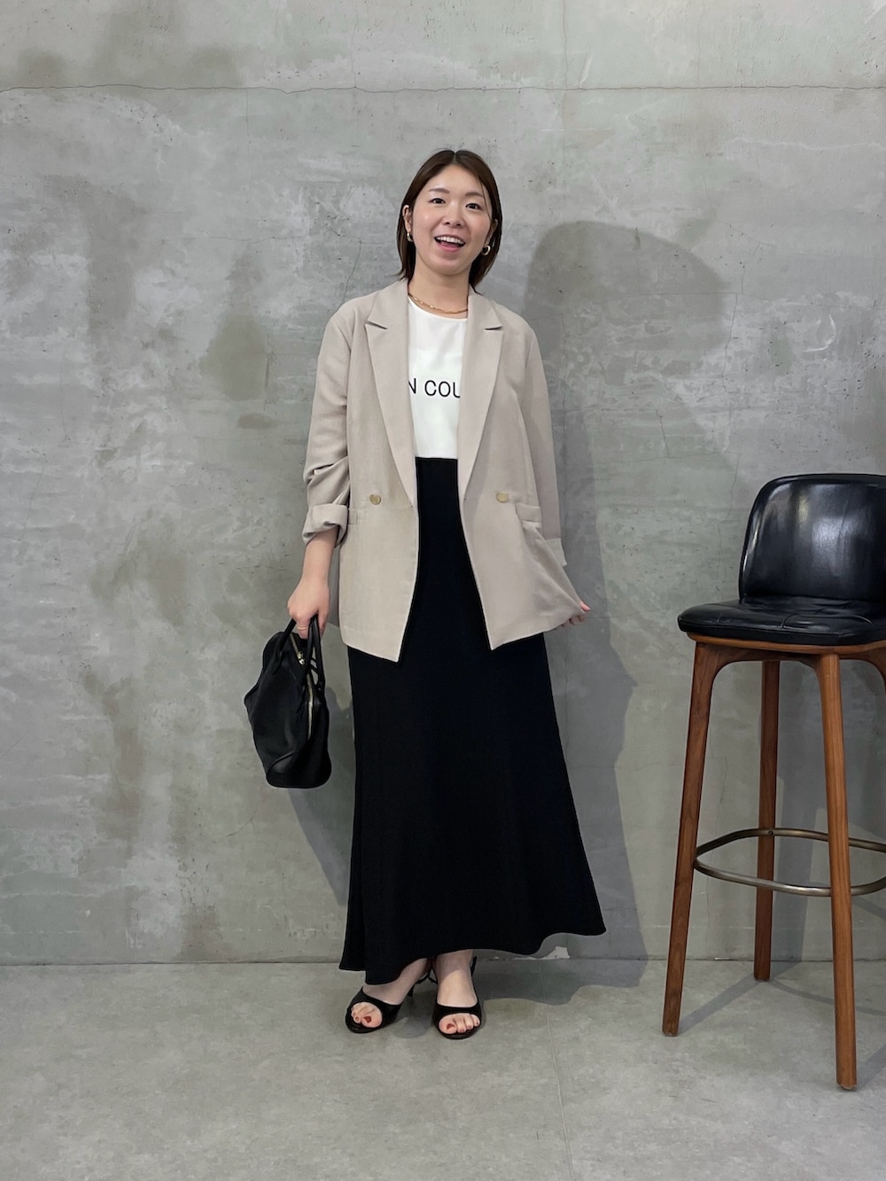 ベージュ系のテーラードジャケット、ブラック系のスカート、ホワイト系のTシャツ/カットソーを着用したレディースの春コーディネートの5枚目の写真