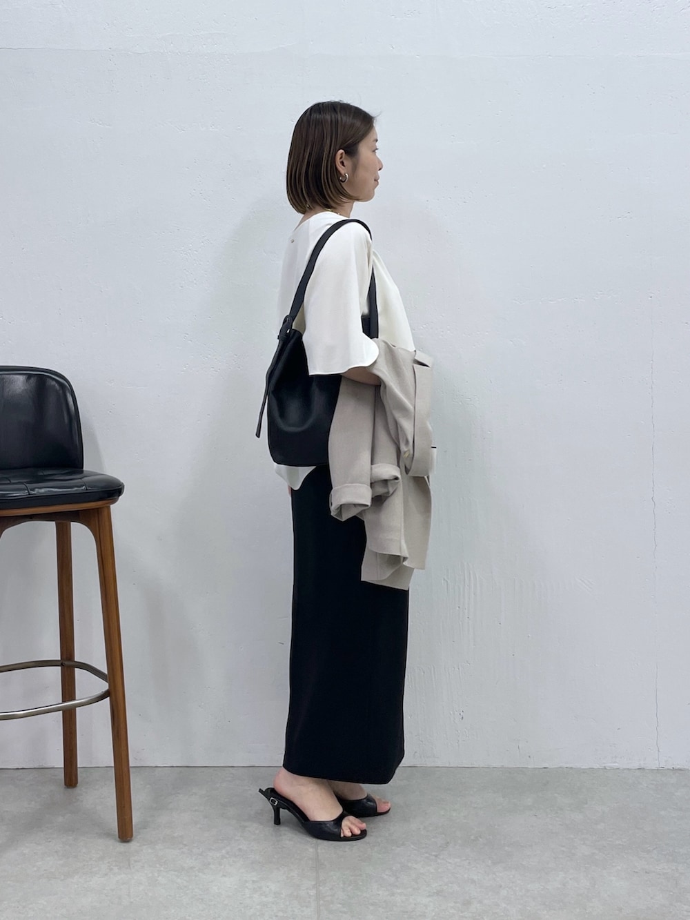 ブラック系のスカート、ベージュ系のテーラードジャケット、ホワイト系のシャツ/ブラウスを着用したレディースの春コーディネートの2枚目の写真