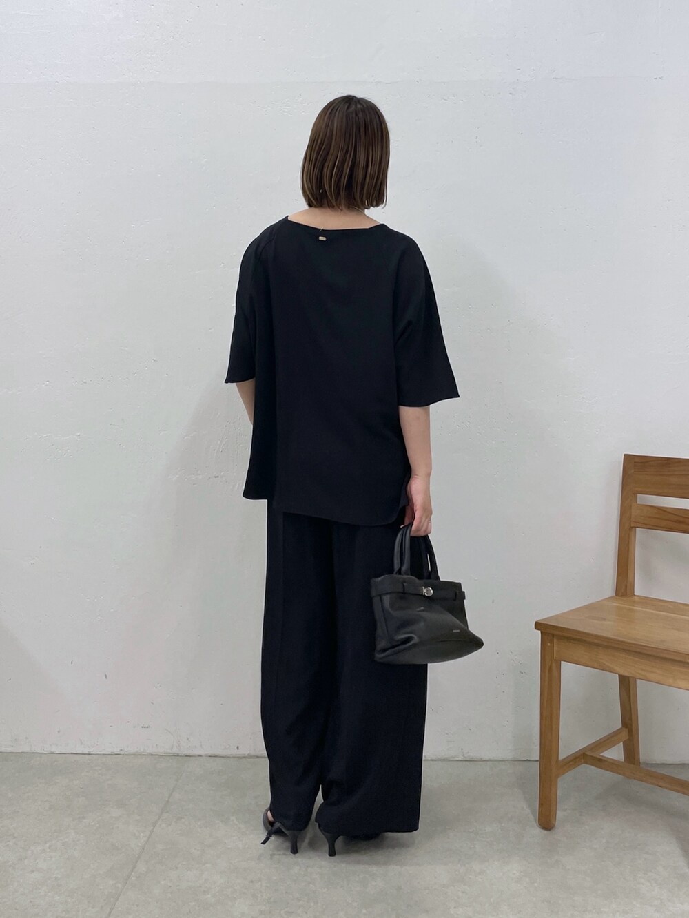 ブラック系のシャツ/ブラウス、ブラック系のスラックス、ブラック系のトートバッグを着用したレディースの春コーディネートの3枚目の写真