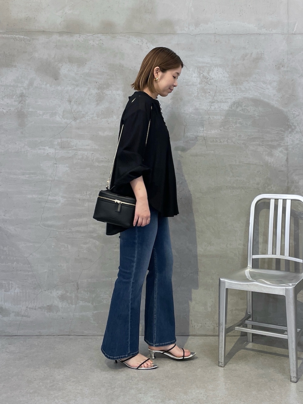 ブルー系のデニムパンツ、ブラック系のシャツ/ブラウス、ブラック系のショルダーバッグを着用したレディースの夏コーディネートの4枚目の写真