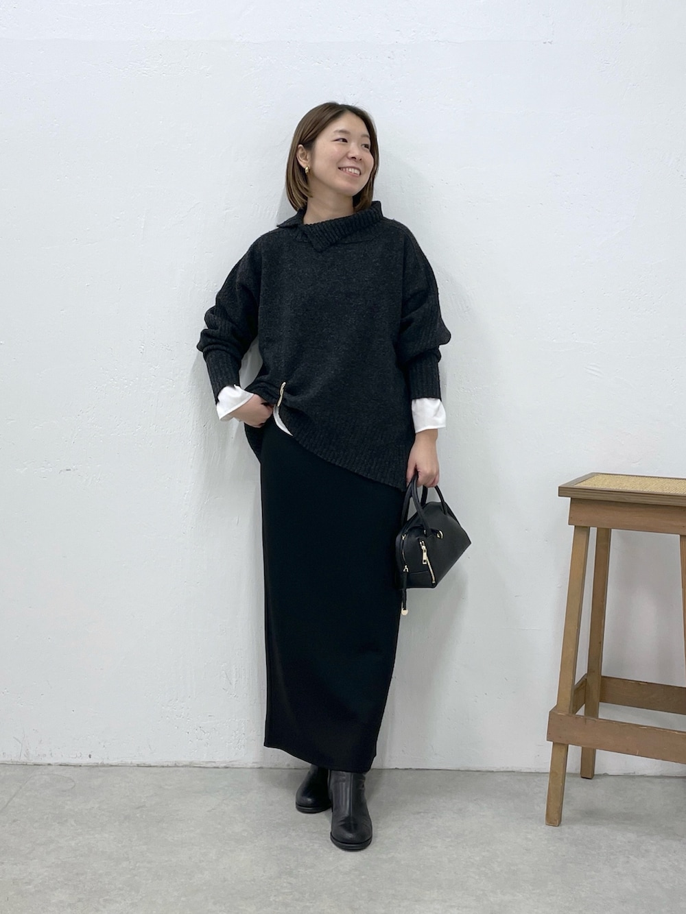 グレー系のニット/セーター、ホワイト系のシャツ/ブラウス、ブラック系のスカートを着用したレディースの冬コーディネートの4枚目の写真