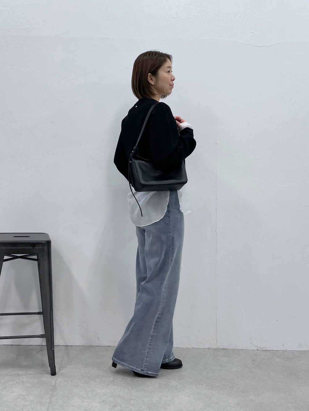 ブラック系のカーディガン/ボレロ、ホワイト系のTシャツ/カットソー、ブルー系のデニムパンツを着用したレディースの冬コーディネートの4枚目の写真