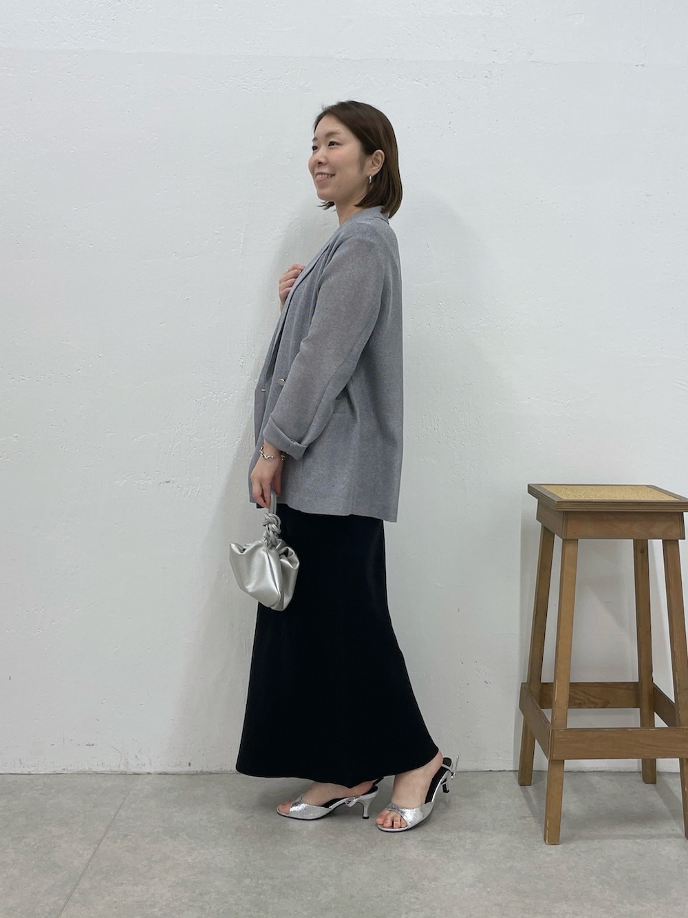 ブラック系のワンピース、グレー系のテーラードジャケット、シルバー系のネックレスを着用したレディースの春コーディネートの2枚目の写真