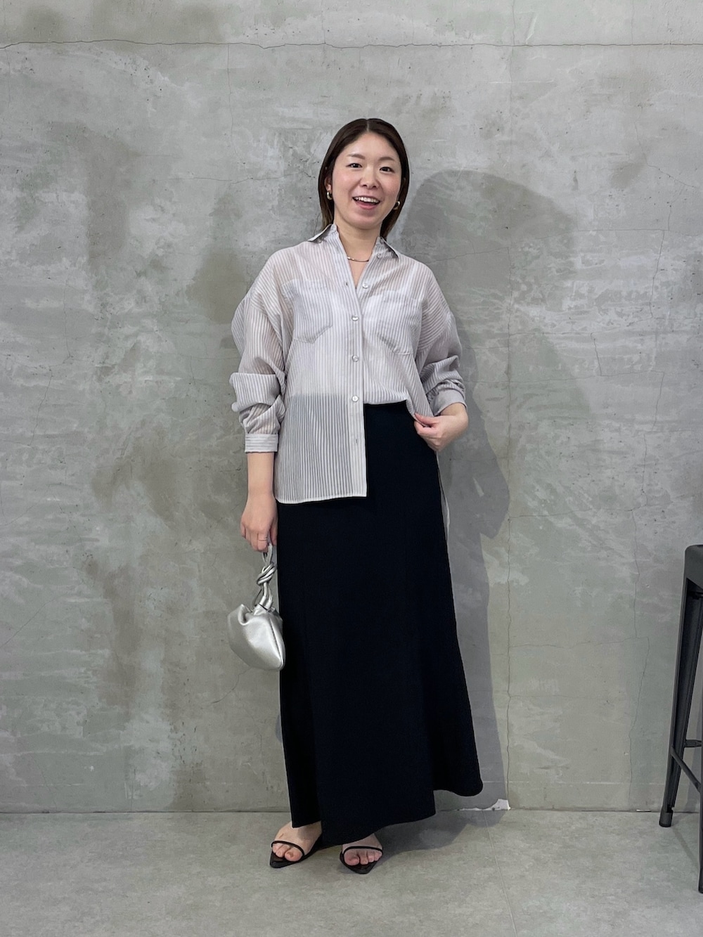 ブラック系のスカート、グレー系のシャツ/ブラウスを着用したレディースの春コーディネートの5枚目の写真