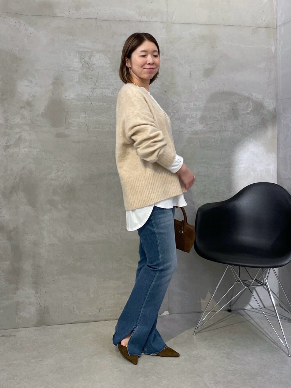 ベージュ系のニット/セーター、ブルー系のデニムパンツ、ブラウン系のバッグを着用したレディースの秋コーディネートの3枚目の写真