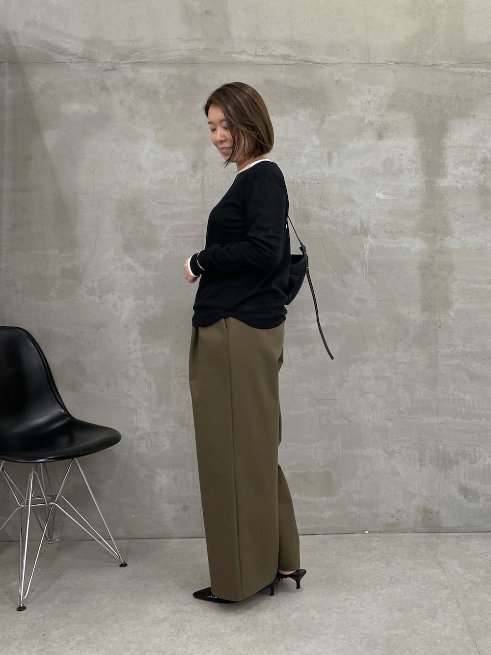 グリーン系のチノパンツ、ブラック系のTシャツ/カットソー、ホワイト系のTシャツ/カットソーを着用したレディースの冬コーディネートの3枚目の写真