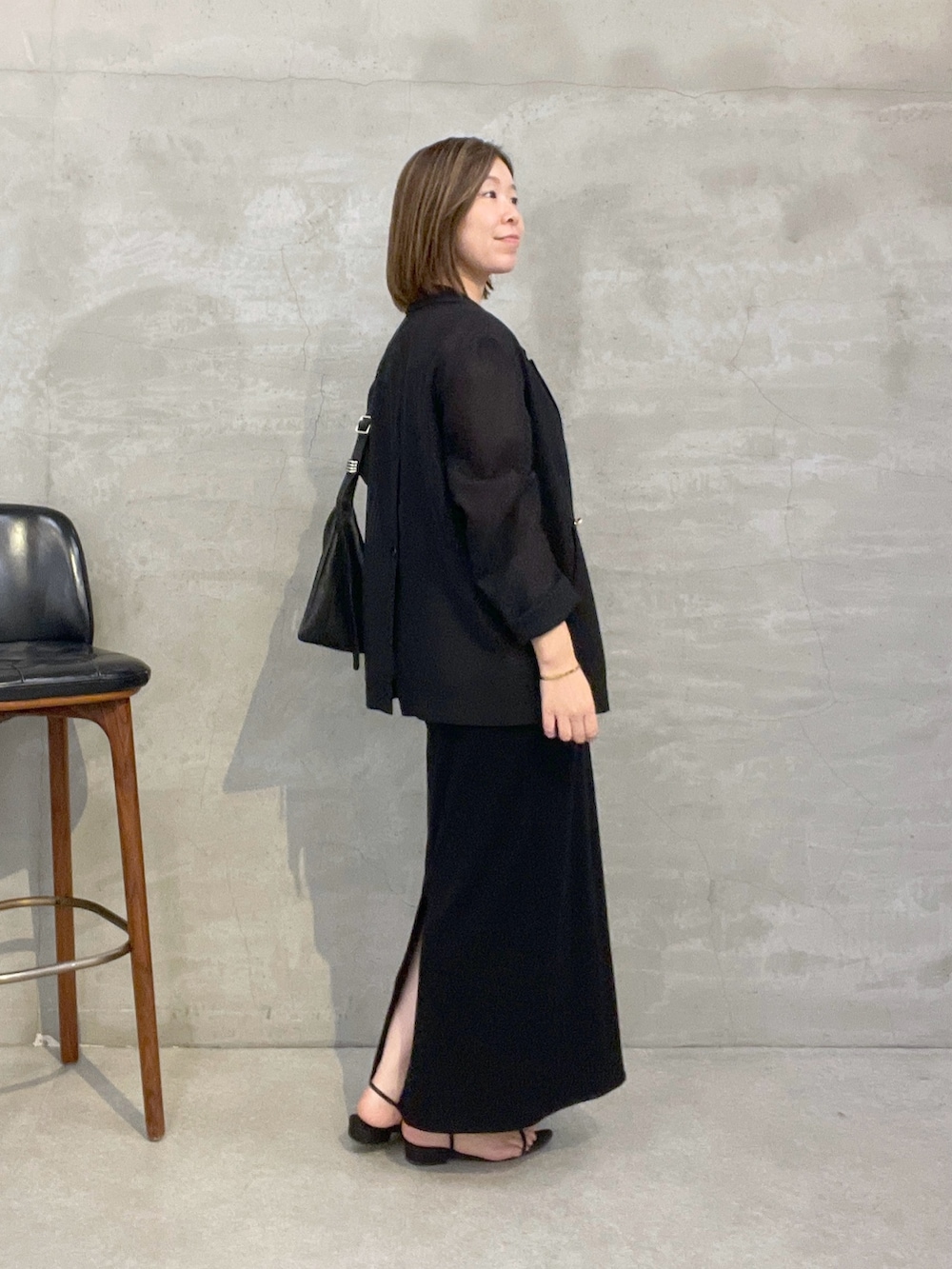 ブラック系のワンピース、ブラック系のテーラードジャケット、ブラック系のショルダーバッグを着用したレディースの夏コーディネートの4枚目の写真