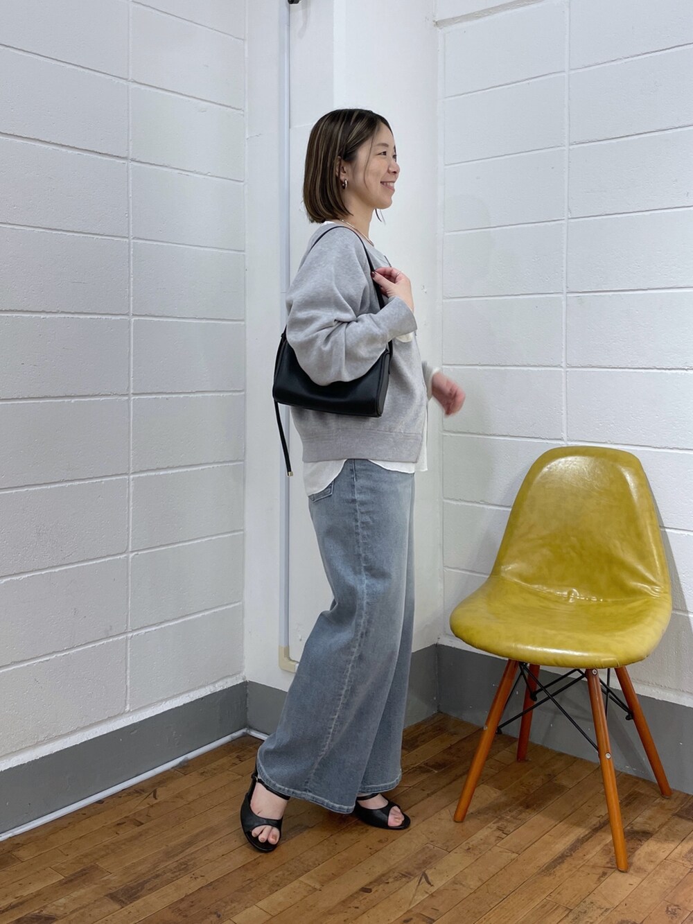 ホワイト系のニット/セーター、ホワイト系のTシャツ/カットソー、ブルー系のデニムパンツを着用したレディースの夏コーディネートの2枚目の写真