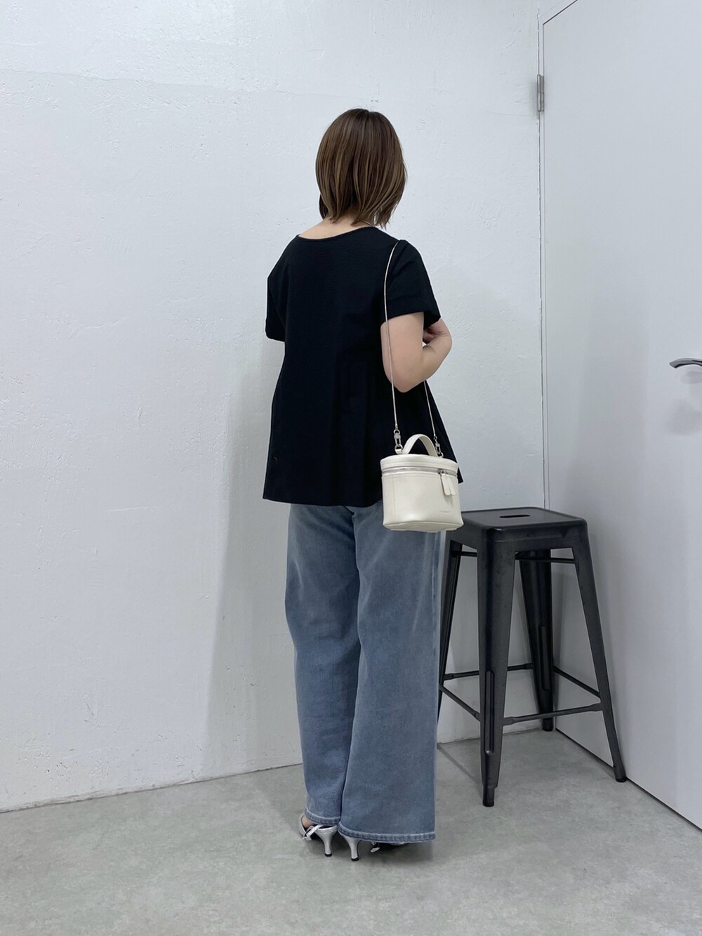 ブラック系のシャツ/ブラウス、ブルー系のデニムパンツ、ホワイト系のショルダーバッグを着用したレディースの春コーディネートの4枚目の写真