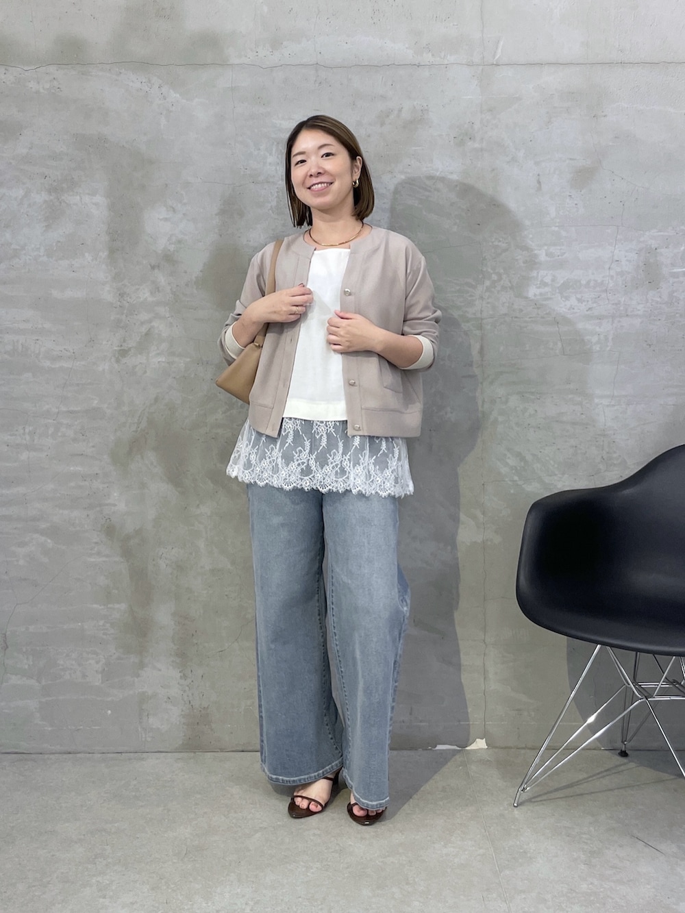 ベージュ系のカーディガン/ボレロ、ホワイト系のシャツ/ブラウス、ブルー系のデニムパンツを着用したレディースの秋コーディネートの4枚目の写真