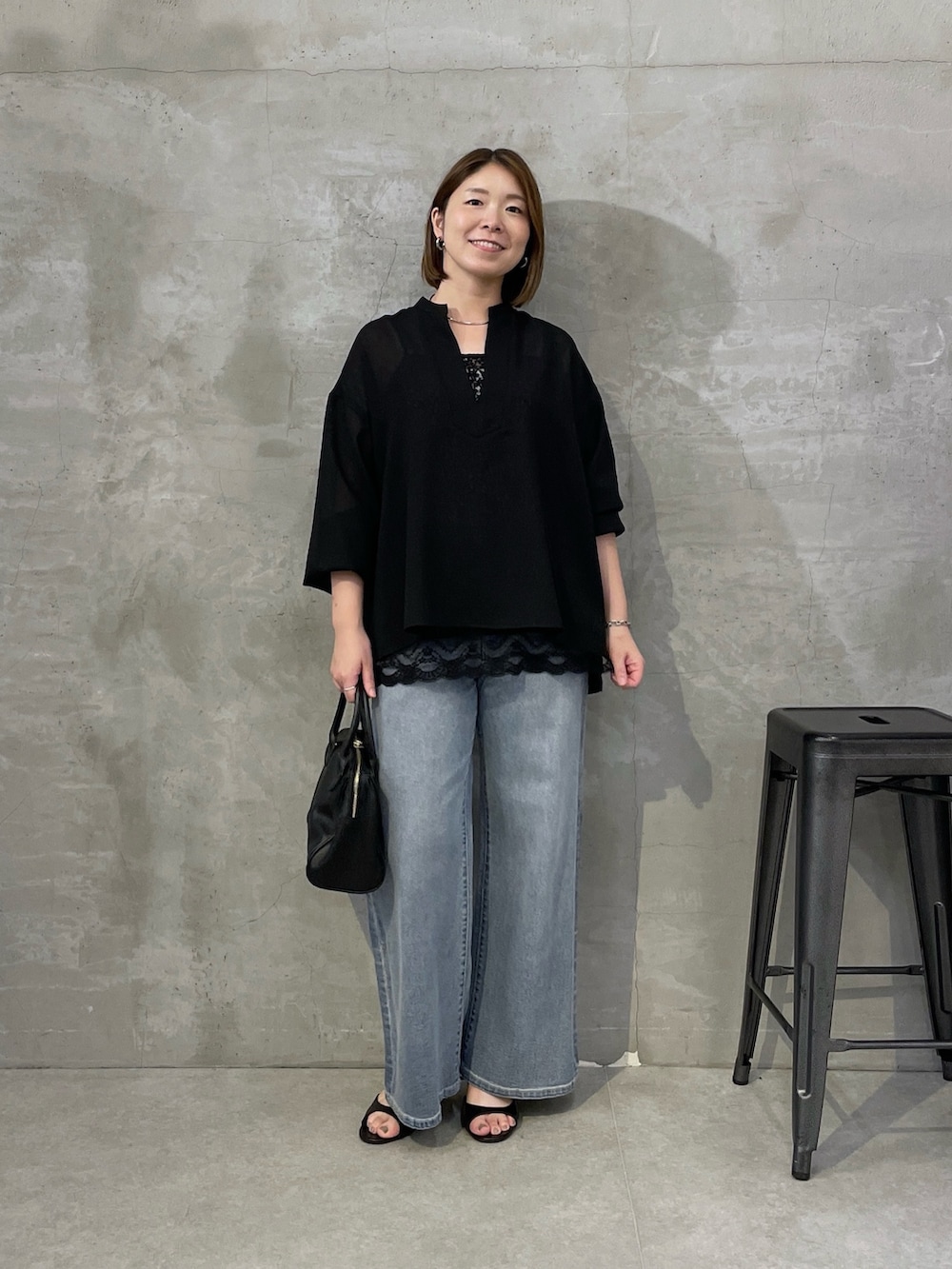 ブラック系のシャツ/ブラウス、ブラック系のキャミソール、ブルー系のデニムパンツを着用したレディースの夏コーディネートの4枚目の写真
